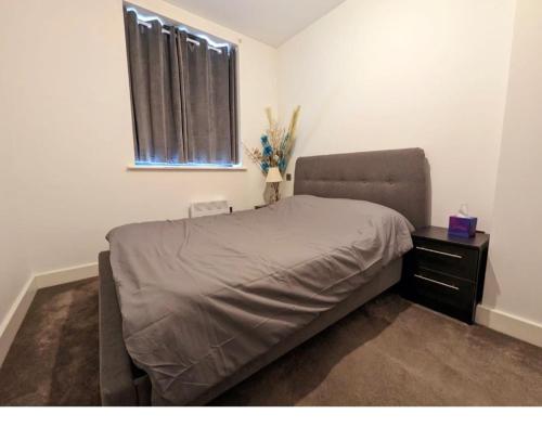 a bedroom with a bed with a nightstand and a window at Free Parking Luxury 1 Bed,BHX,NEC,RESORTS WORLD. in Birmingham
