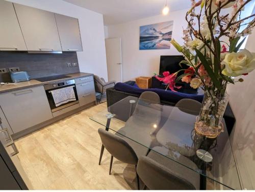 a living room with a glass table with a vase of flowers at Free Parking Luxury 1 Bed,BHX,NEC,RESORTS WORLD. in Birmingham