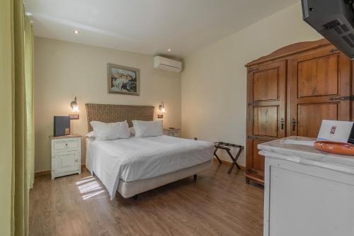 a bedroom with a white bed and a wooden floor at Villa Rosa in Lagos