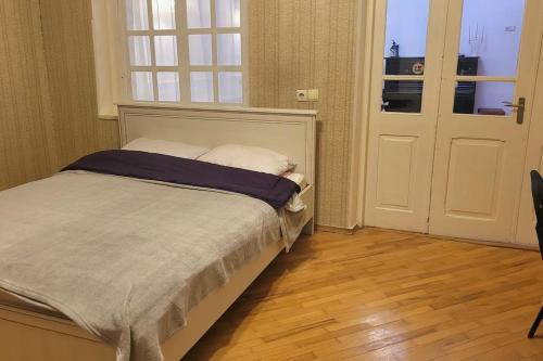 een slaapkamer met een bed, een raam en een deur bij Victoria apartment In Tbilisi in Tbilisi City