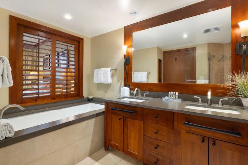 uma casa de banho com 2 lavatórios e um espelho grande em Ko Olina Beach Villas O414 em Kapolei