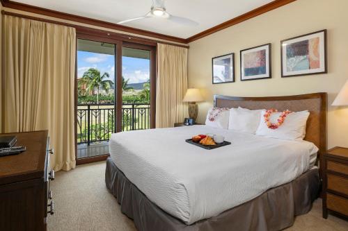 a bedroom with a bed and a balcony at Ko Olina Beach Villas O414 in Kapolei