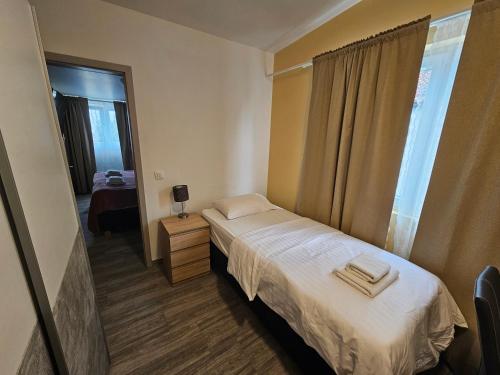 a small bedroom with a bed and a window at Royal Apartments & Rooms in Zagreb
