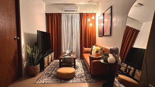 ein Wohnzimmer mit einem Sofa und einem TV in der Unterkunft 1618D at The Hive Residences in Taytay