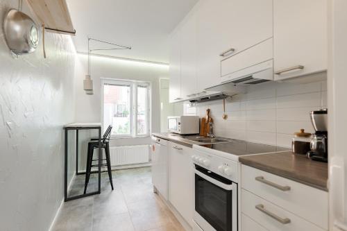 a kitchen with white cabinets and a stove top oven at Studio apartment in lake views in Tampere