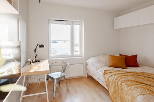 a bedroom with a bed and a desk and a window at Studio apartment in lake views in Tampere