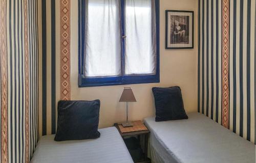 エル・カンページョにある2 Bedroom Cozy Apartment In El Campelloのベッド2台と窓が備わる客室です。