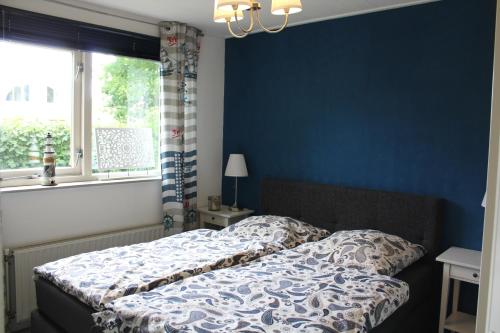 ein Schlafzimmer mit einem Bett und einer blauen Wand in der Unterkunft Kustverhuur, Vakantiepark Fort Soleil 45 in Breskens