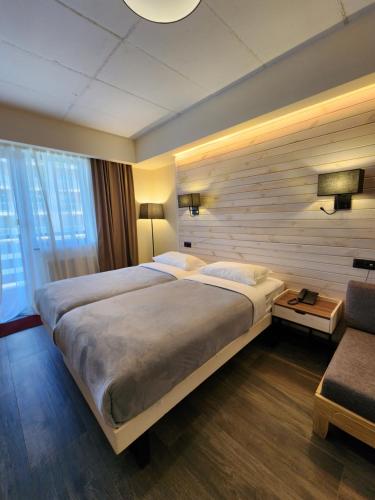 Habitación de hotel con cama grande y sofá en Gudauri Hills Apart Hotel, en Gudauri