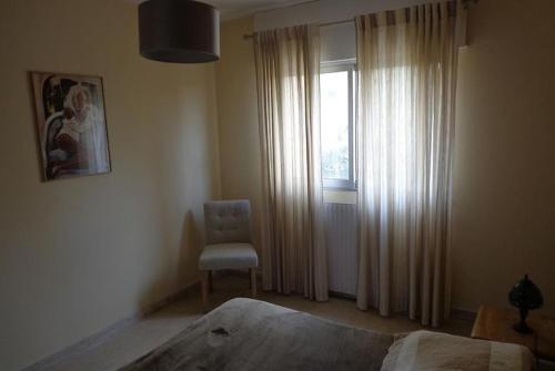 1 dormitorio con 1 cama, 1 silla y 1 ventana en Ajaccio routes des sanguinaires grand F2 en Ajaccio