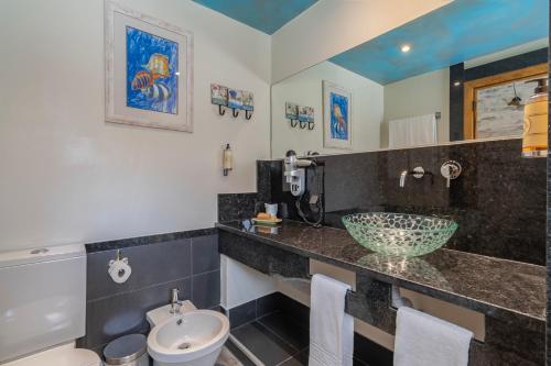 a bathroom with a sink and a toilet at Villa Rosa in Lagos