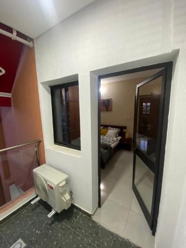 Zimmer mit einem Zimmer mit einem Bett und einem Spiegel in der Unterkunft Appart Neuf et Lumineux à 2 Pas d'Angre Chu in Abidjan