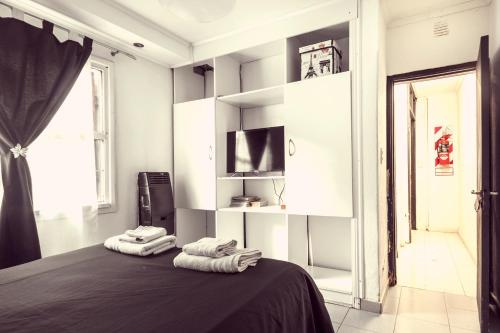 a bedroom with two towels on a bed with a television at Carabelli Propiedades II in Río Grande