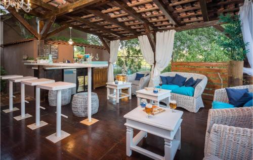 un patio con bar, tavoli e sedie di Nice Home In Bilice With Kitchen a Bilice (Bilizze)