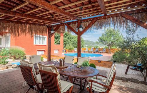 un patio con mesa, sillas y piscina en Nice Home In Bilice With Kitchen en Bilice
