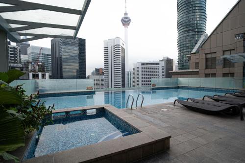 a swimming pool on top of a building with a city at 400m to KLCC Bukit Bintang Pavillion KLCC LRT walking distance in Kuala Lumpur