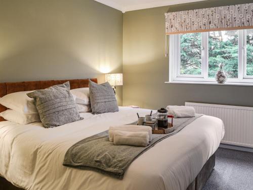 a bedroom with a large white bed with a window at Daisy By The Sea in Scarborough