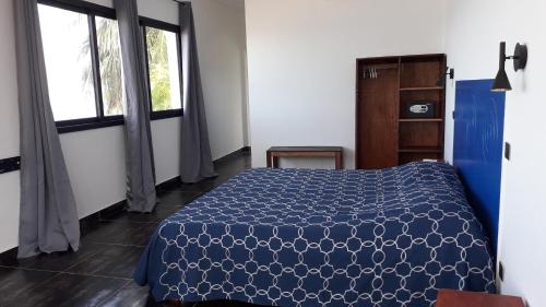 Ramena Beach Hotel في Ramena: غرفة نوم بسرير ازرق ونافذة