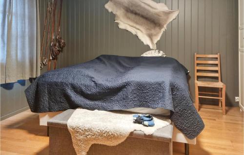 ein Schlafzimmer mit einem Bett mit einer blauen Decke und einem Stuhl in der Unterkunft 7 Bedroom Awesome Home In Tjrhom in Tjørhom