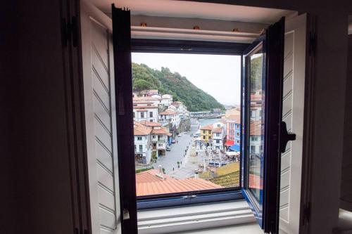 una ventana con vista a una ciudad en Beautiful house at the seaside, en Cudillero