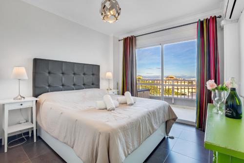 a bedroom with a bed and a large window at Diana by IVI Real Estate in Benalmádena