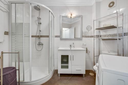 a white bathroom with a shower and a sink at Diana by IVI Real Estate in Benalmádena