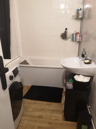 une salle de bain avec une baignoire et un lavabo dans l'établissement Appartement proche aéroport Beauvais-tille, à Beauvais