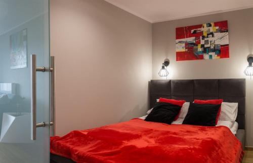 1 dormitorio con 1 cama con manta roja en VacationClub – Bukowa 17A Apartament G.2, en Wisła