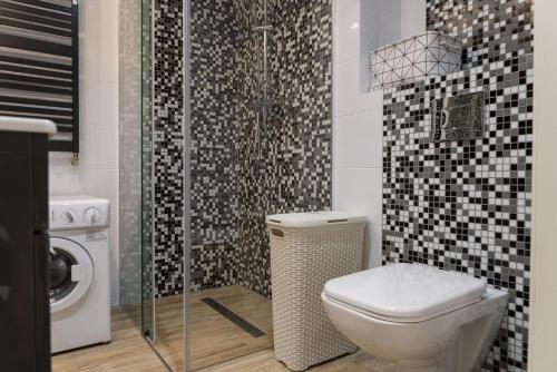 a bathroom with a toilet and a shower at VacationClub – Bukowa 17A Apartament G.2 in Wisła