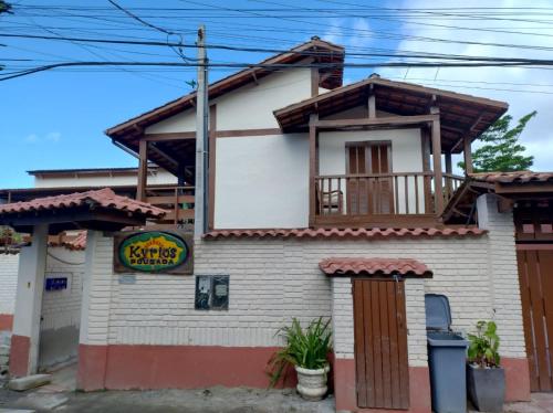 a small white building with a balcony at Pousada Kyrios in Maresias