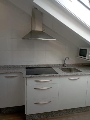 a white kitchen with a sink and a stove at Atico Salvadas in Santiago de Compostela
