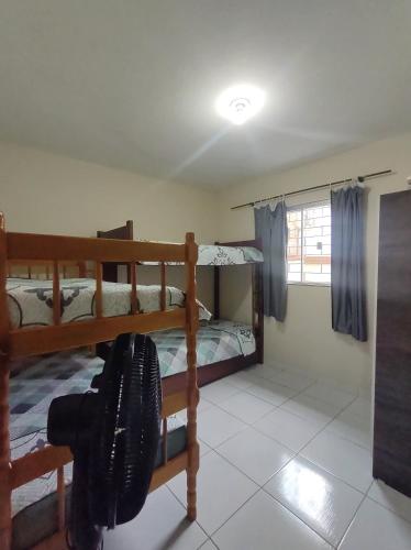 Casa Aconchegante em Itapema في ايتابيما: غرفة نوم بسريرين بطابقين ونافذة