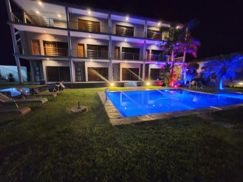 een groot gebouw met een zwembad in de nacht bij HOTEL GANI in Manjacaze