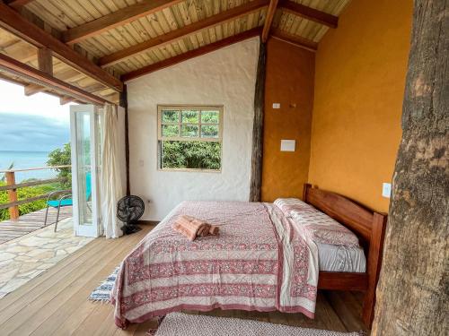 a bedroom with a bed on a wooden deck at Chalé com vista para o mar in Ilhabela