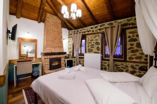 a bedroom with a white bed and a fireplace at Agios Germanos in Agios Germanos