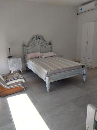 1 dormitorio con 1 cama y 1 silla en Casa en el Centro 3 ambientes en Gualeguaychú
