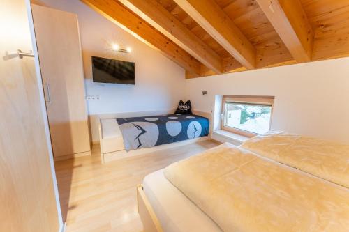 ein Schlafzimmer mit einem Bett und einem TV an der Wand in der Unterkunft Haus Montana in Damüls