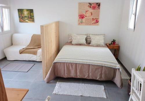 サンミゲル・デ・アボナにあるCASA RURAL MARYの小さなベッドルーム(ベッド1台、ソファ付)