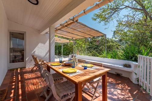 une table et des chaises en bois sur une terrasse dans l'établissement Le Maquis, Véritable havre de paix sur les hauteurs d'Ajaccio, à Alata