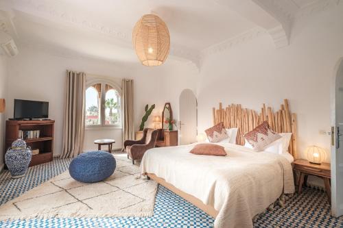 a bedroom with a large bed and a tv at Villa Beldi in Essaouira