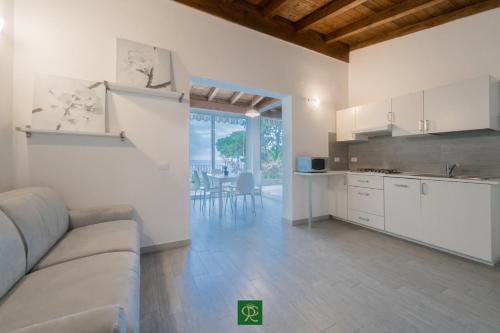 a living room with a couch and a kitchen at Albatros in Capoliveri