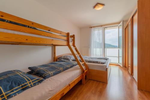 two bunk beds in a room with a window at Residence Le Mont in Trutnov