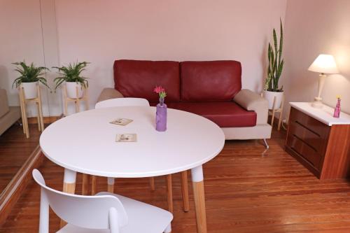sala de estar con mesa blanca y sofá rojo en Hermoso PH en Buenos Aires! en Buenos Aires
