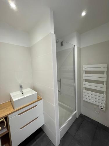a white bathroom with a sink and a shower at T3cab-Peyragudes-61m2-8pers in Germ