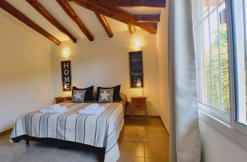 a bedroom with a bed and a large window at La Isolina Casa en Chacras de Coria in Chacras de Coria