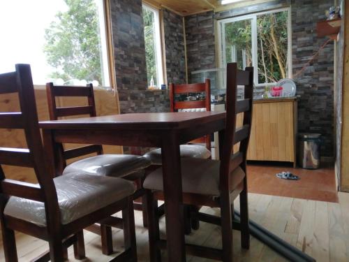 a dining room with a wooden table and chairs at Casa Aoni in Puerto Montt