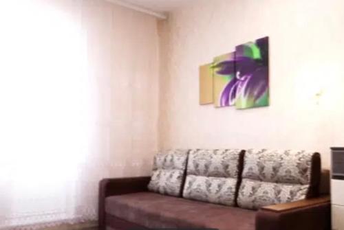 a living room with a couch and a painting on the wall at VIP apart 680 in Tbilisi City