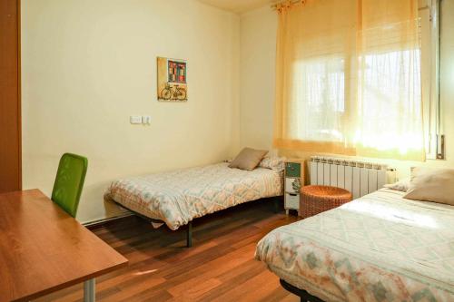 1 Schlafzimmer mit 2 Betten, einem Tisch und einem Fenster in der Unterkunft Can Camps Besalú Alojamiento con jardín privado in Besalú