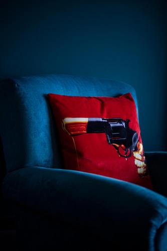 a hair dryer sitting on a red pillow on a couch at Chy conary in Carbis Bay