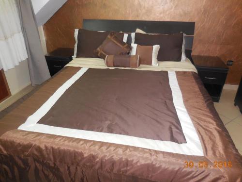- un lit avec une couverture brune et un porte-monnaie dans l'établissement Bel Appartement à Ifrane, à Ifrane